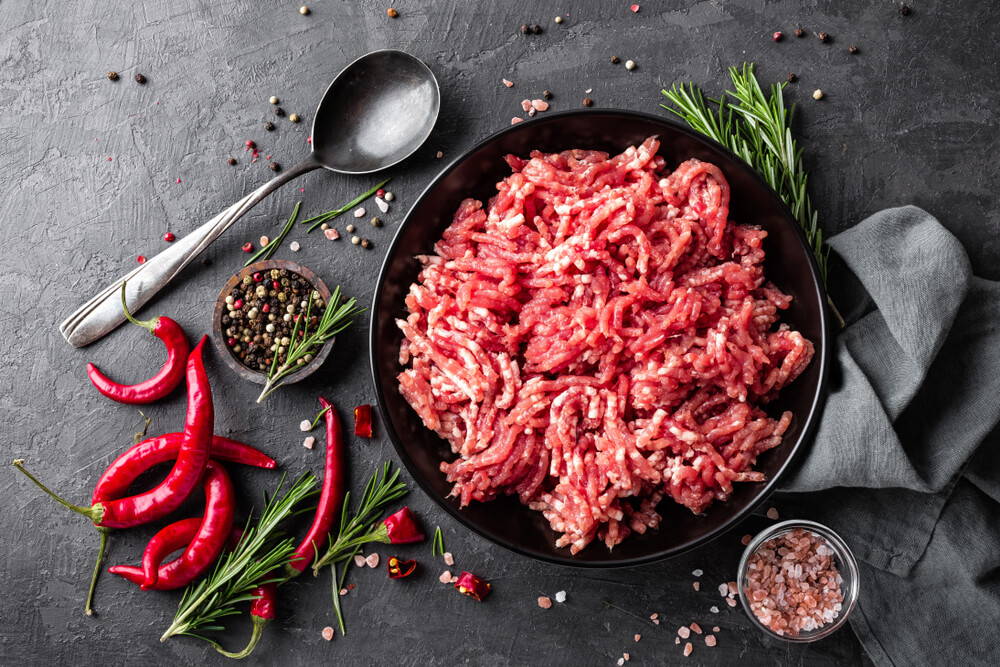 Ground Meat With Ingredients for Cooking on Black Background.
