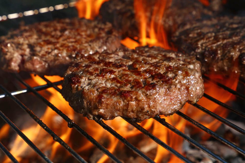Close Up Beef or Pork Meat Barbecue Burgers for Hamburger Prepared Grilled on Bbq Fire Flame Grill High Angle View