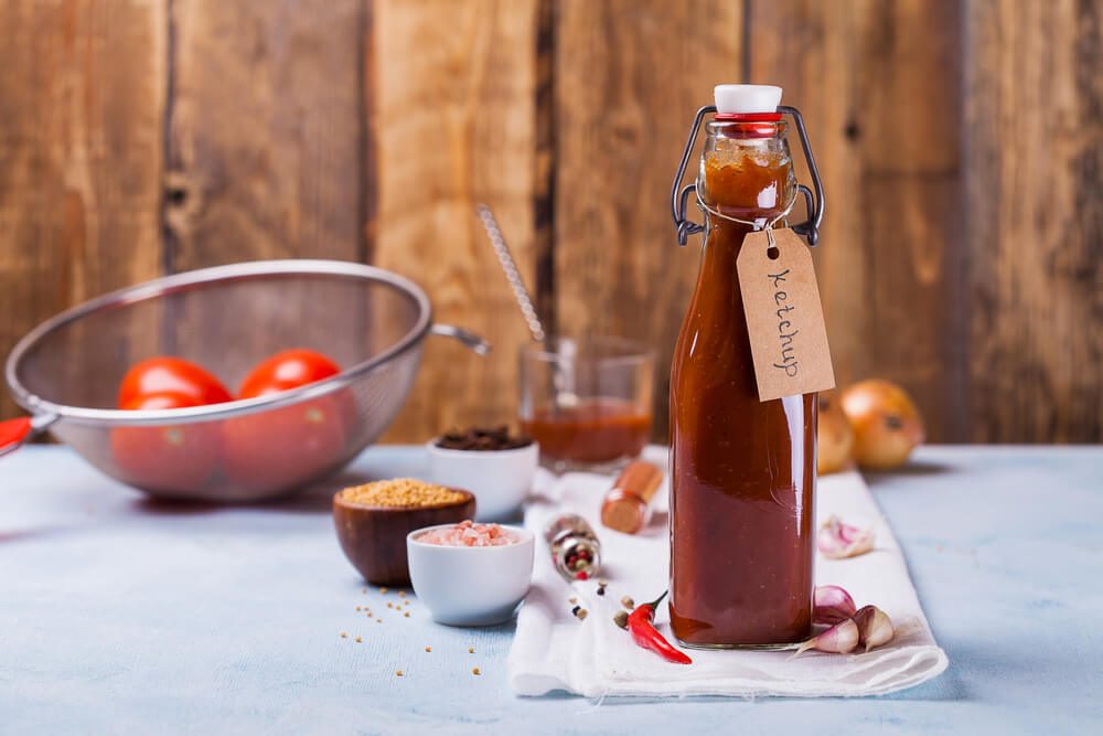 Homemade Ketchup in Bottle With Label, Ingredients on the Table.