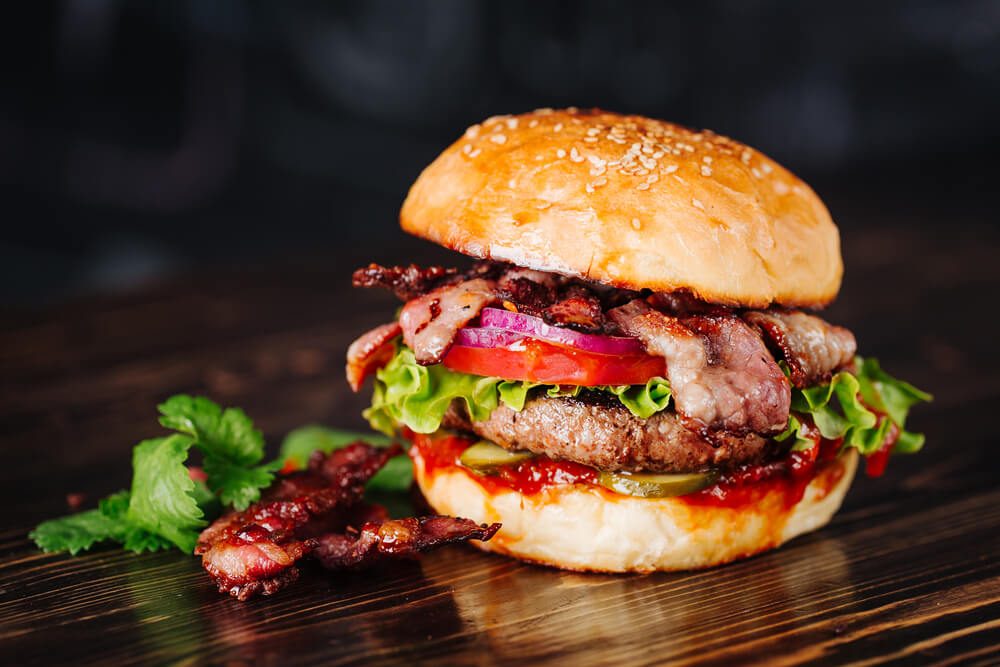 Burger With Bacon Meat Tomato and Lettuce on Wooden Background