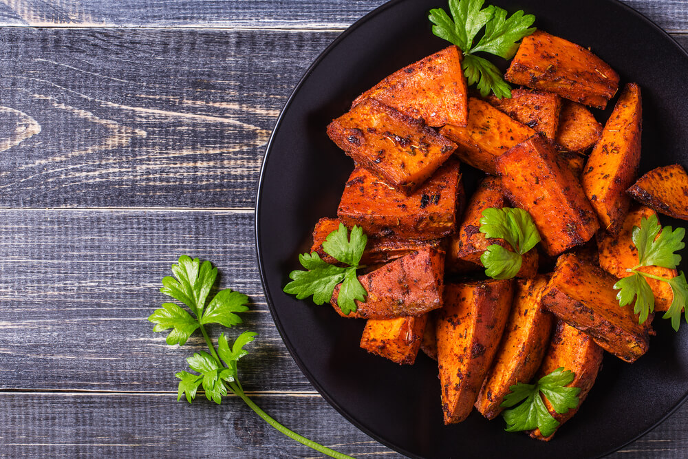 Homemade Cooked Sweet Potato With Spices and Herbs on Dark Background