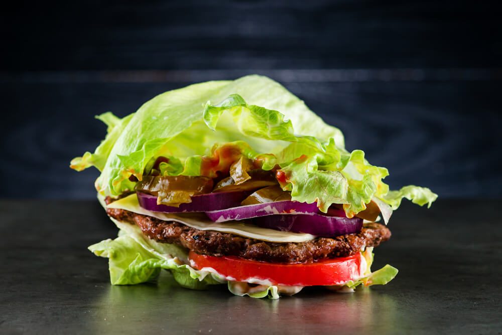 Low carb Burger With Salad and Beef Homemade All Beef Lean Hamburger Lettuce Wrap Which Is a Low Carb Alternative for Those on Paleo Diet and Topped With Tomatoes and Onion