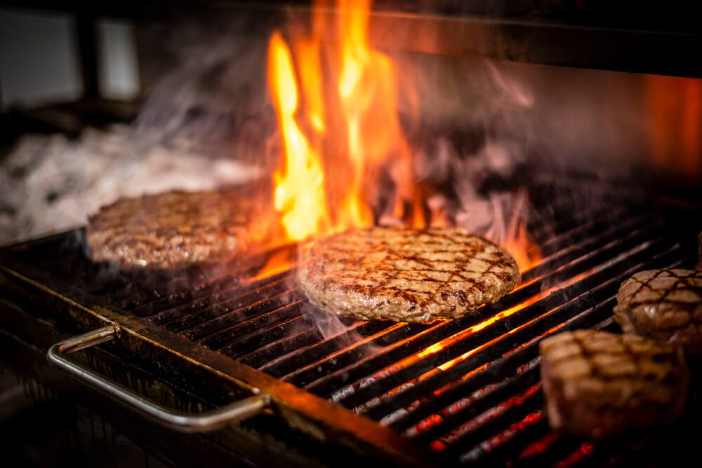 Large Piece of Meat Burger Being Grilled With Flames