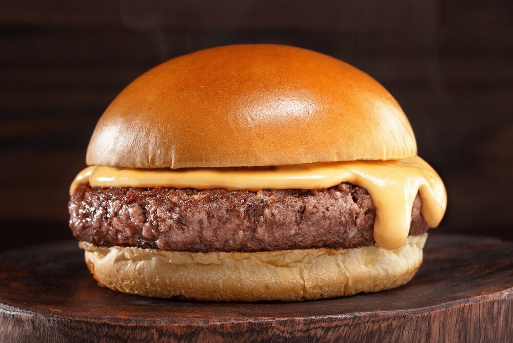 Hamburger With Cheddar Cream and Fresh and Tasty Brioche Bun on Smoke and Dark Wooden Table