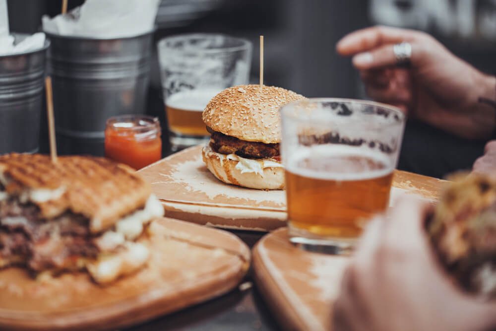 Delicious Pub Food. Burgers and Glasses of Beer on Wooden Plates
