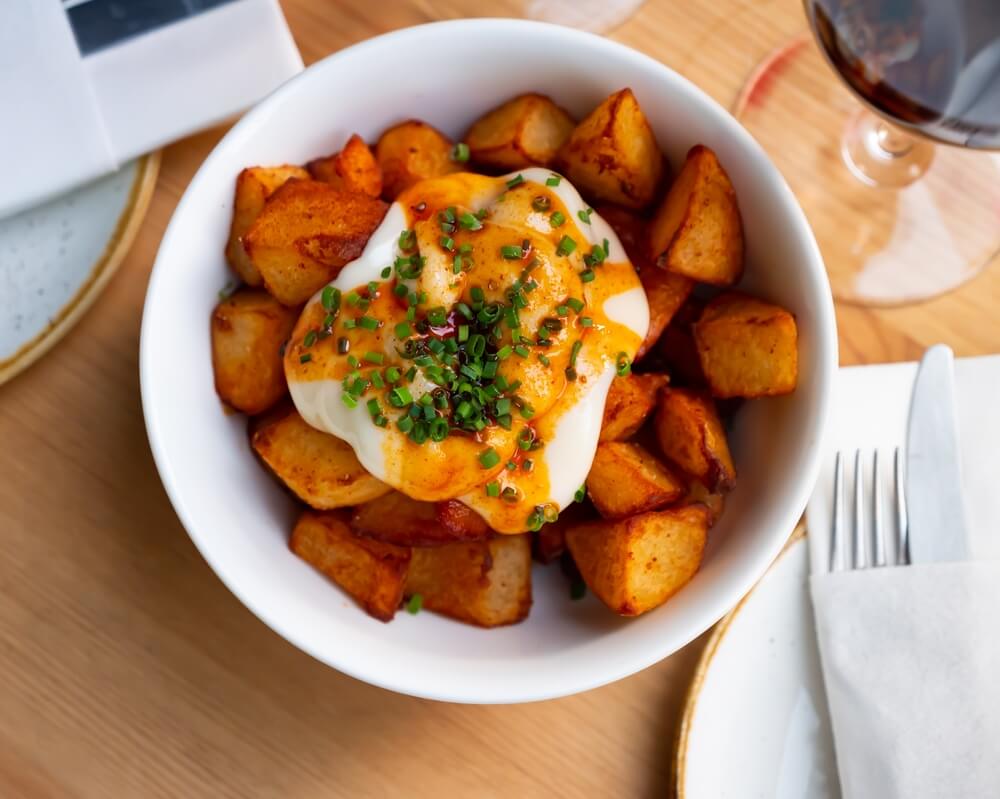 Delicious Baked Potatoes With Spicy Creamy Sauce Aioli Sprinkled With Chopped Scallions Popular Spanish Dish Patatas Bravas
