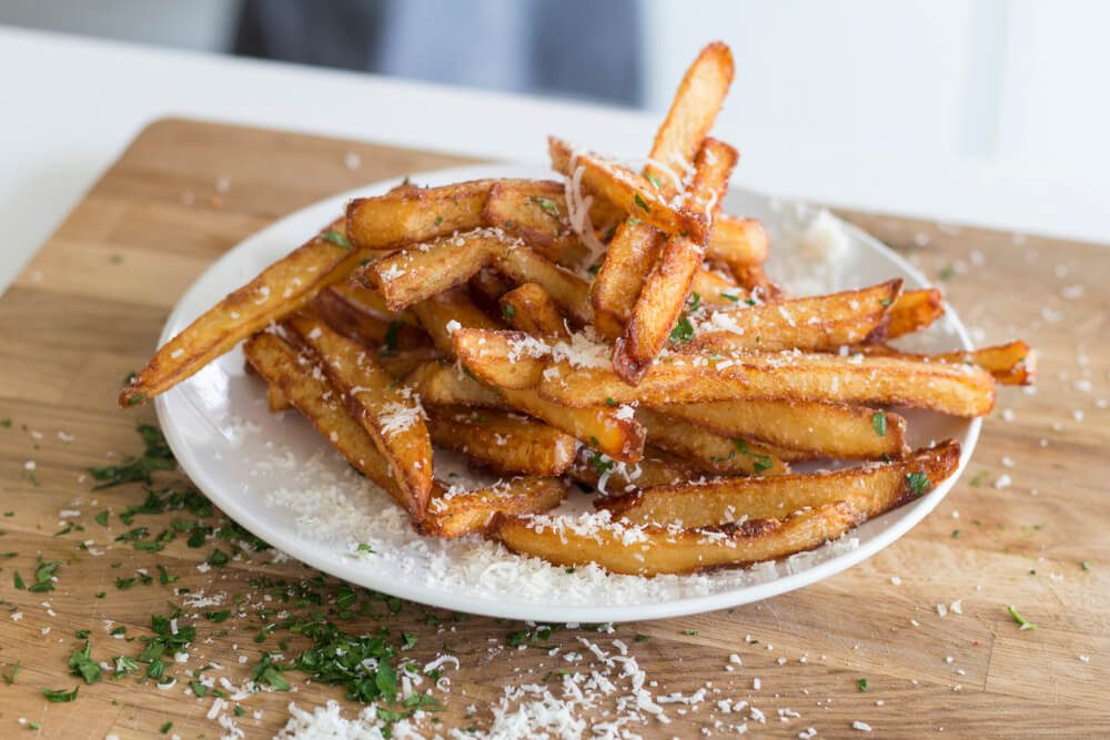Homemade Truffle French Fries With Parsley Parmesan Truffle Oil on Wooden Cutting Board
